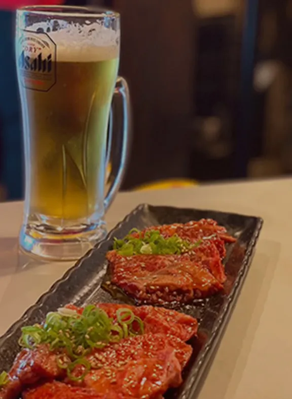 焼肉とビールジョッキが並んだ食事シーン